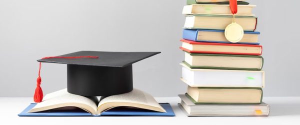 front-view-stacked-books-graduation-cap-open-book-education-day_23-2149241017